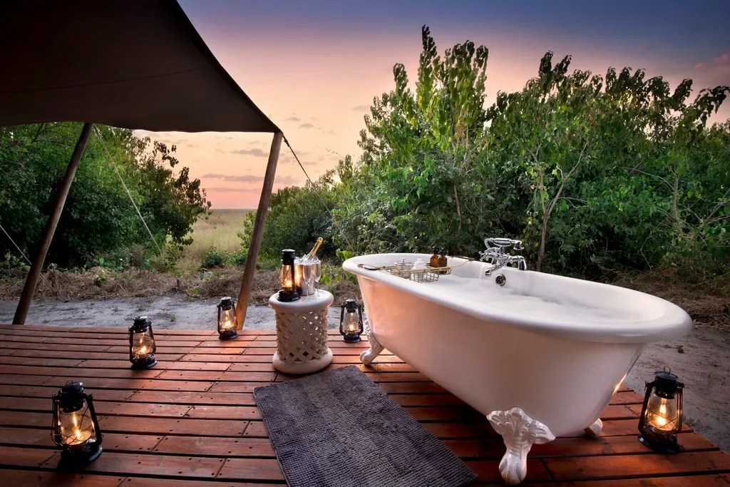 Outdoor clawfoot bath with lanterns at Linyanti Bush Camp, Botswana, romantic bush bubble bath