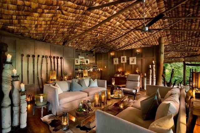 Lake Manyara Tree Lodge, Tanzania – candle‑lit lounge with carved timber and woven textures