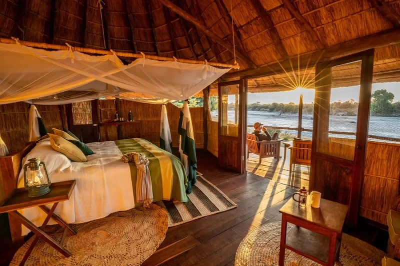 Classic thatched chalet bedroom with river outlook, Nsolo Bush Camp, South Luangwa, Zambia