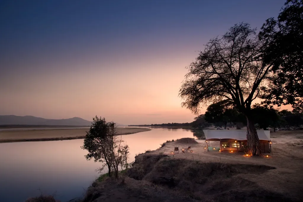 zambezi-expeditions-riverside-tented-camp-lit-at-dusk-above-the-zambezi-zambezi-1024w