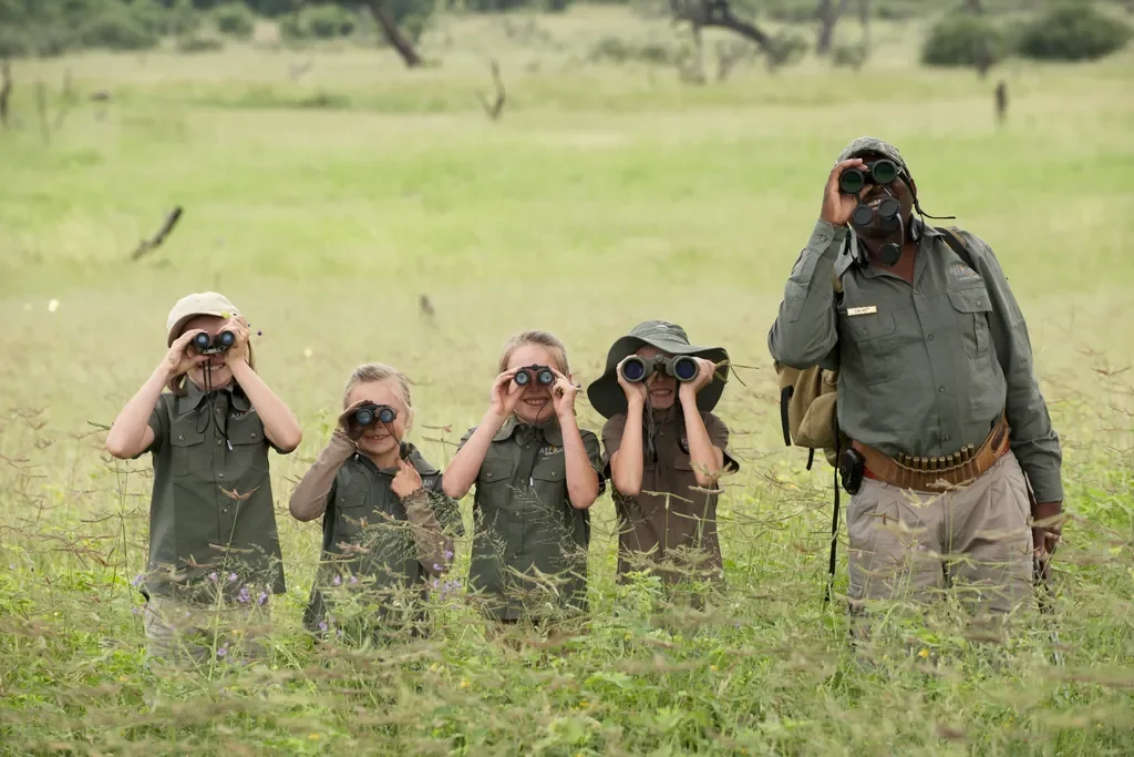 Children’s safari club with binoculars in the grasslands, Somalisa Acacia family-friendly camp