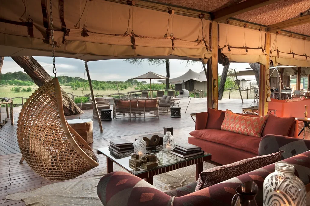 Open-plan lounge looking onto the deck and waterhole, Somalisa Acacia tented camp Hwange
