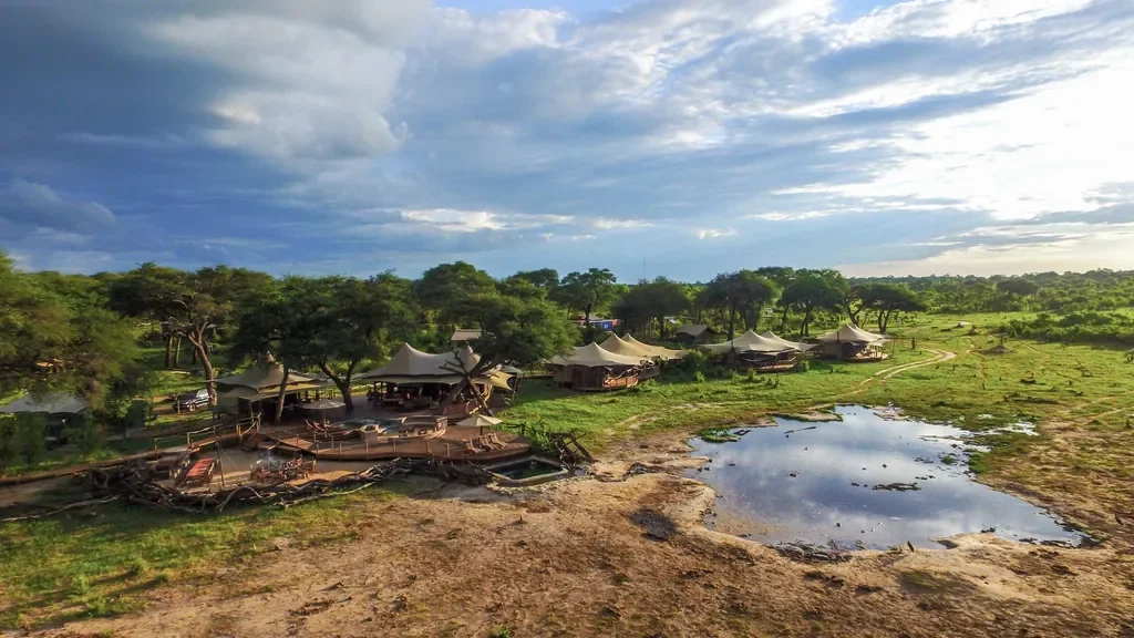 Drone view of Somalisa Acacia camp and waterhole in green season, Hwange National Park