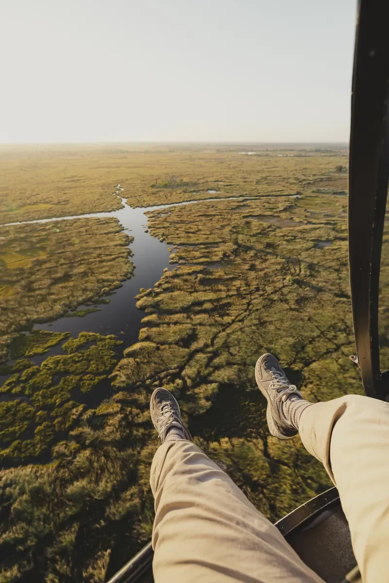 Doors-off helicopter scenic flight over Okavango Delta channels from Khwai Lediba Expeditions Camp, Botswana