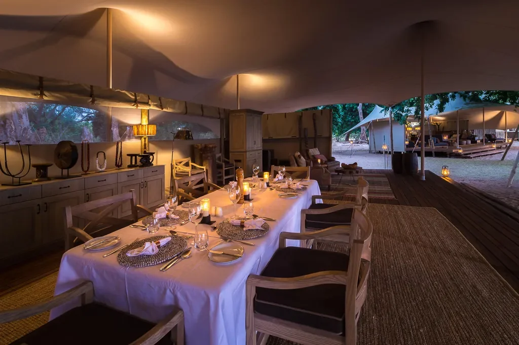 Candlelit dinner table in the mess tent at Little Ruckomechi, Mana Pools National Park, Zimbabwe