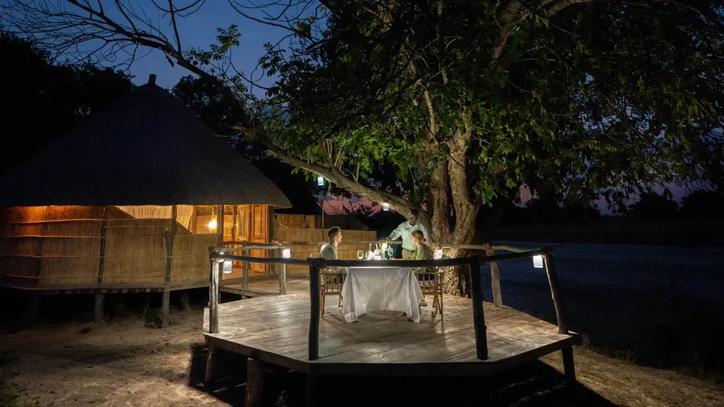 Candlelit dining deck at Nsolo Bush Camp with views of the Luwi River, South Luangwa National Park