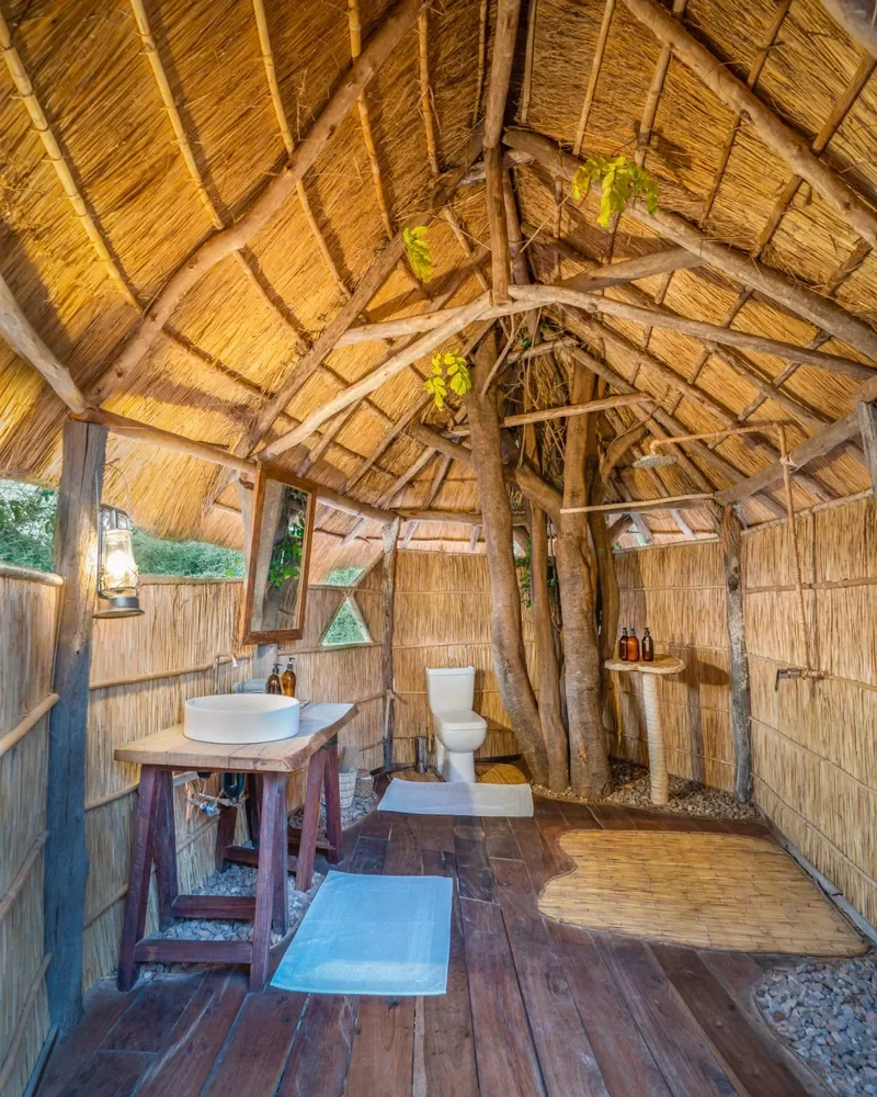 Open air en suite bathroom built around trees, Nsolo Bush Camp, South Luangwa National Park, Zambia