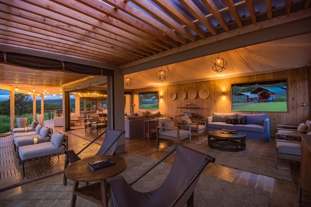 Dunia Camp lounge and wraparound deck with lantern lights overlooking the Serengeti plains