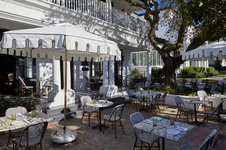 Upper Union courtyard dining beneath parasols at Cape Cadogan, Cape Town