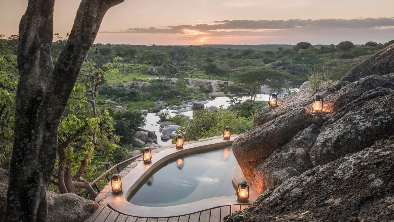 Private cliffside Jacuzzi at Mwiba Lodge with lanterns and river view at sunset in Tanzania
