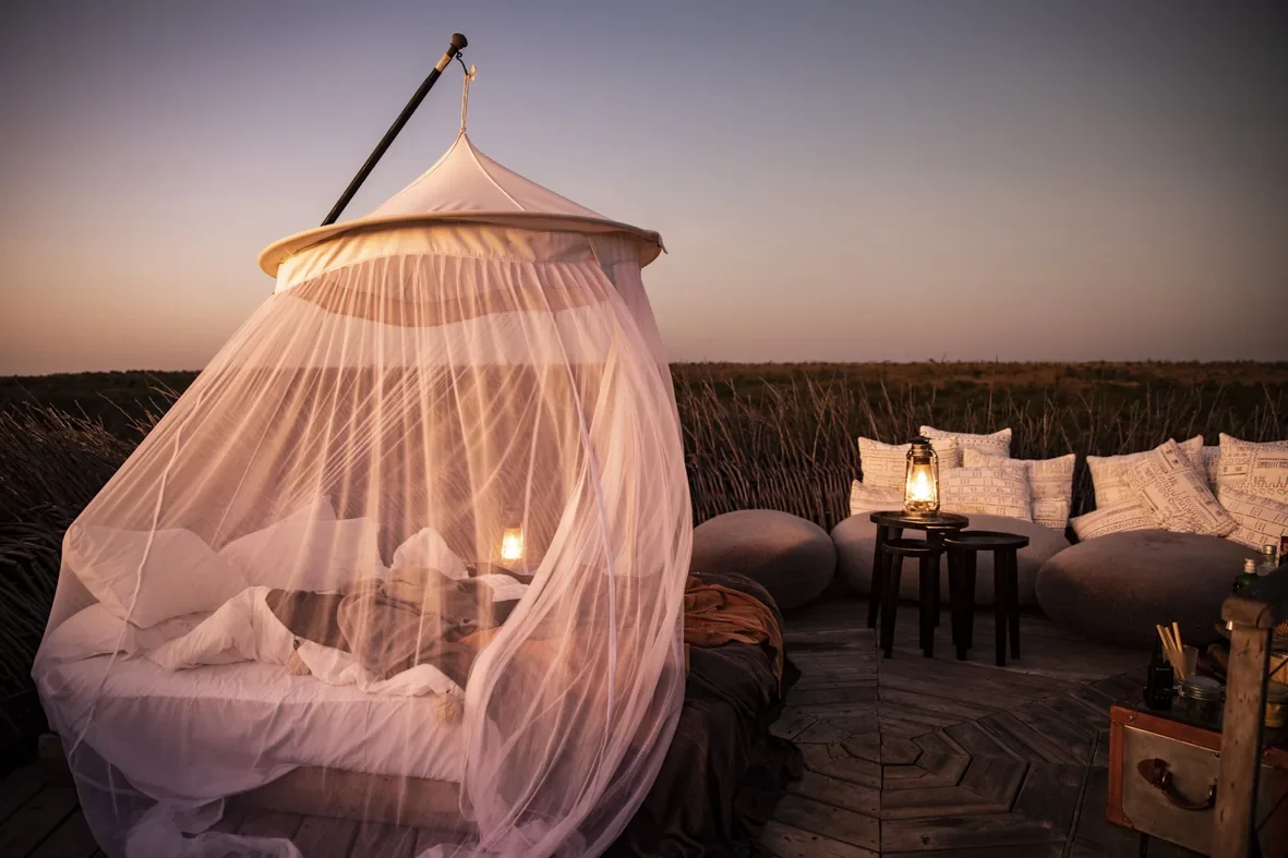 Nay Palad Bird Nest open air bed with sunset light and lounge seating, Segera, Laikipia, Kenya
