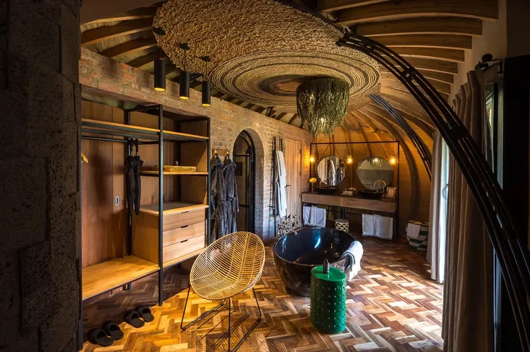Bisate Lodge suite dressing area and freestanding tub, woven ceiling detail Rwanda