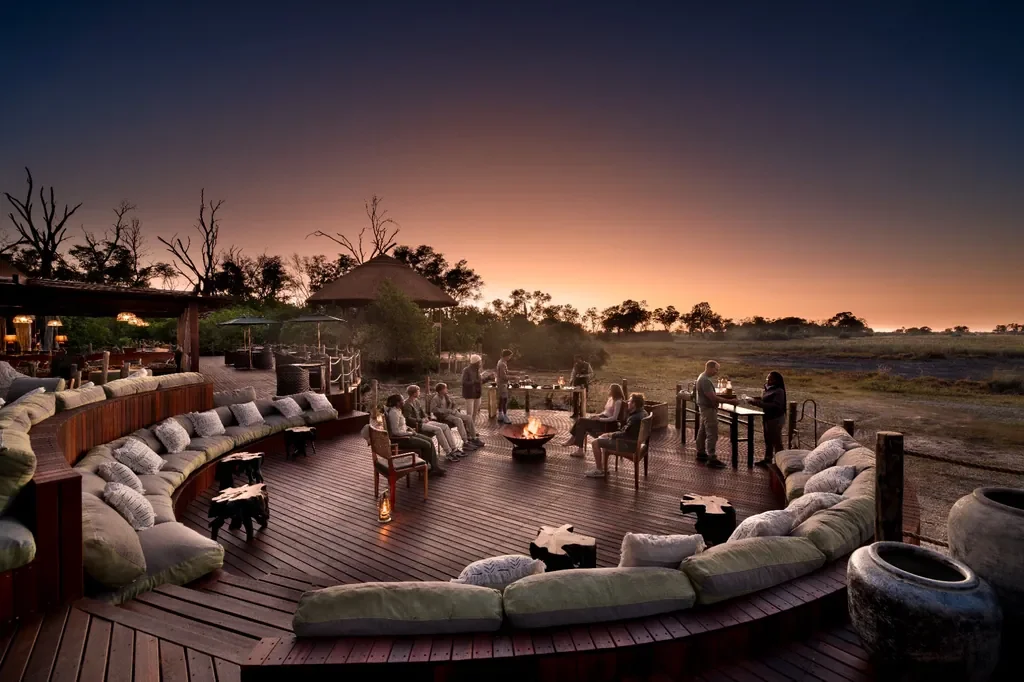 Sunken fire pit and deck lounge at Atzaro Okavango Camp at dusk, Okavango Delta Botswana