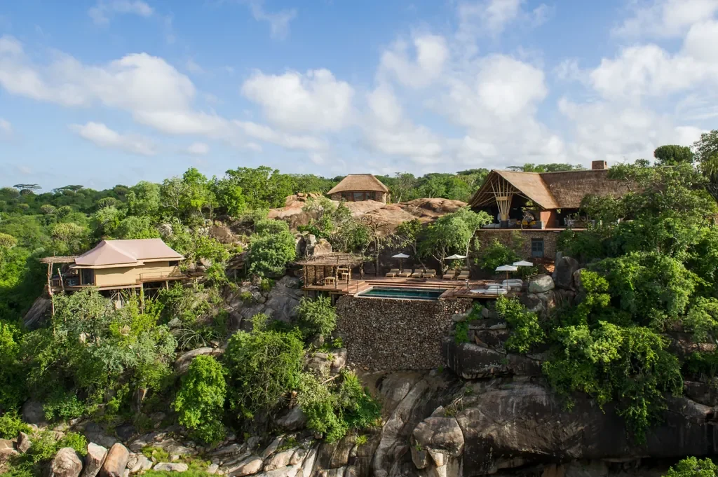 Aerial view of Mwiba Lodge set on rocky kopjes with infinity pool in Tanzania