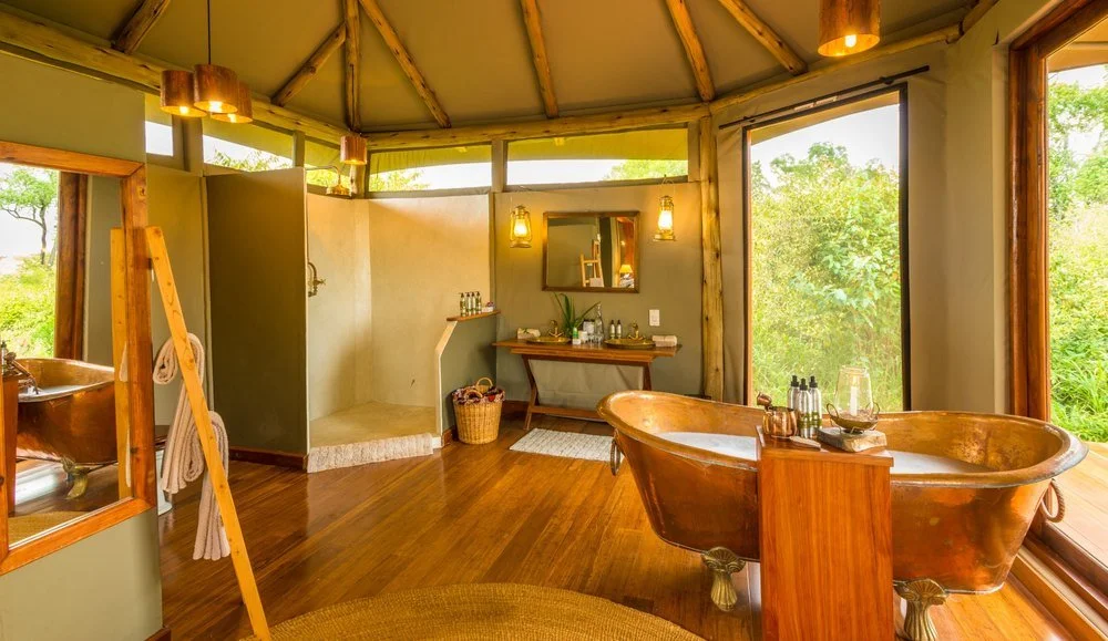 Light‑filled en‑suite bathroom with walk‑in shower and copper accents — Sala’s Camp, Maasai Mara