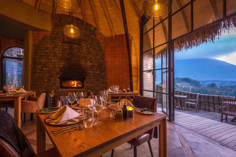 Bisate Lodge dining room with fireplace and panoramic volcano views Rwanda