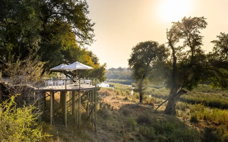 Elevated dining deck at sunrise overlooking the Sabie River at Lion Sands Narina Lodge, Greater Kruger