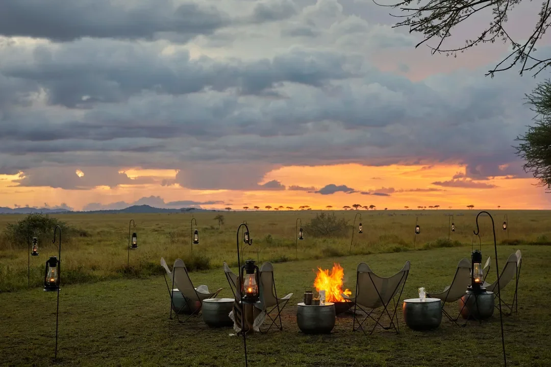 Sundowners around the campfire with lanterns at Mila Tented Camp Serengeti