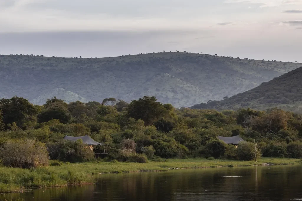 Magashi Camp tents on Lake Rwanyakazinga with rolling hills, Akagera National Park Rwanda