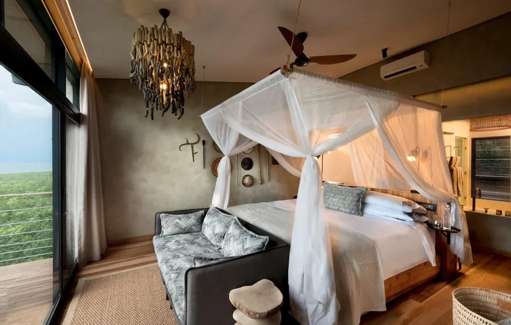 Lake-view suite with canopy bed and private deck at Bumi Hills Safari Lodge, Zimbabwe