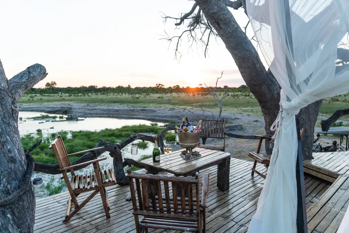 Sunset drinks setup on Somalisa Sleepout deck overlooking a waterhole, Hwange National Park, Zimbabwe