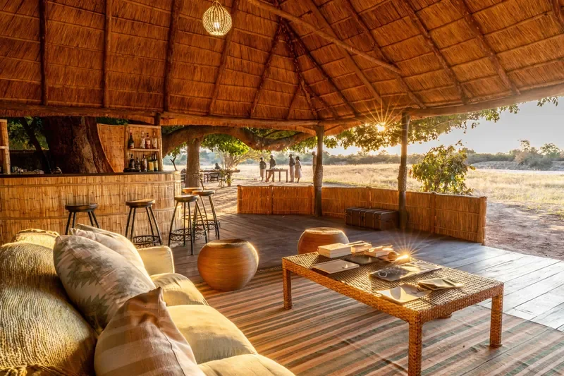 Open air lounge and bar under thatch at Nsolo Bush Camp, South Luangwa National Park, Zambia