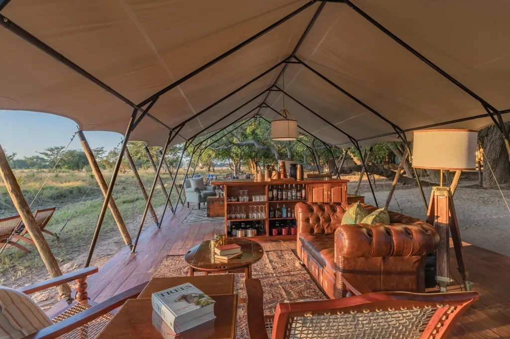 Classic safari lounge and bar inside Time + Tide Luwi main tent, Zambia