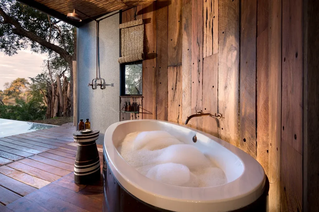 Outdoor bathtub and rain shower on the deck at Thorntree River Lodge, Zambia