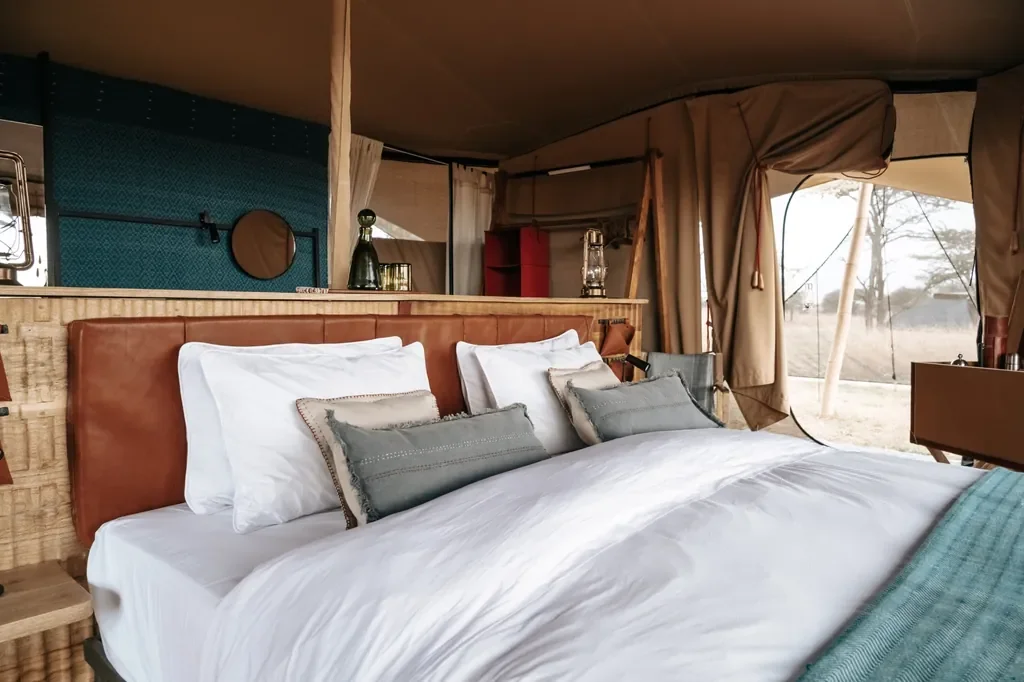 Detail of Usawa tent bedroom with leather headboard and soft linens in the Serengeti