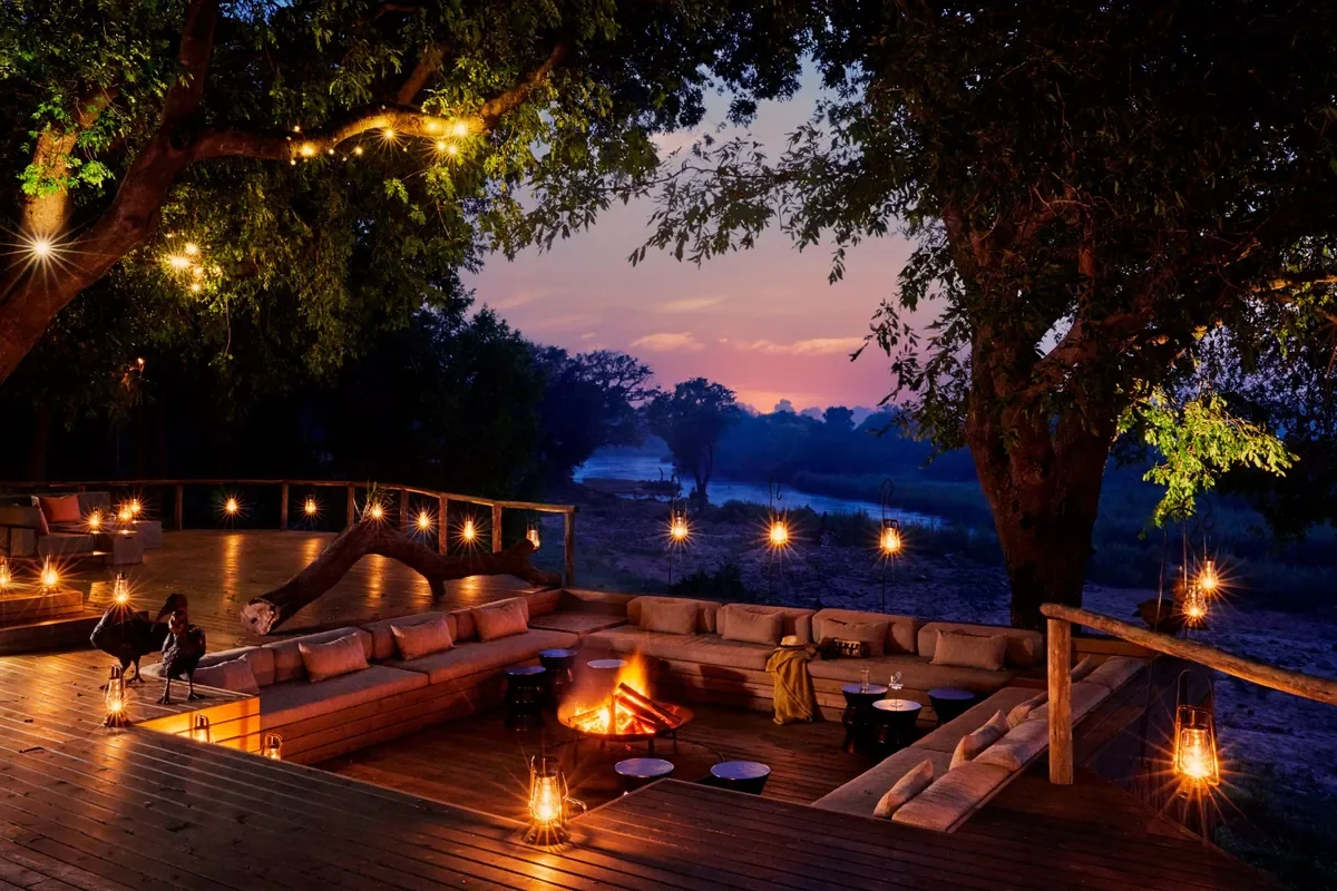 Fire deck at Lion Sands Ivory Lodge, Sabi Sand, Greater Kruger, South Africa with lanterns and sunken seating, ideal for starry-night boma evenings beside the Sabie River