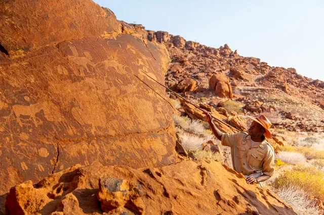 Guide interpreting Twyfelfontein rock engravings near Doro Nawas, UNESCO rock art in Damaraland, Namibia