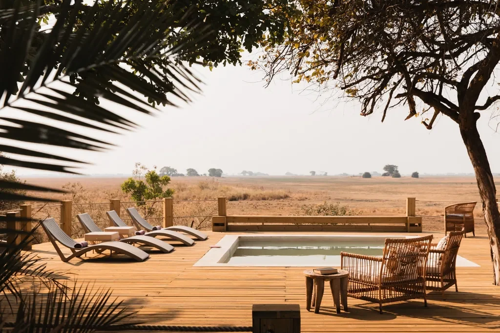 Pool deck with loungers overlooking Busanga Plains, Busanga Bush Camp Kafue National Park Zambia