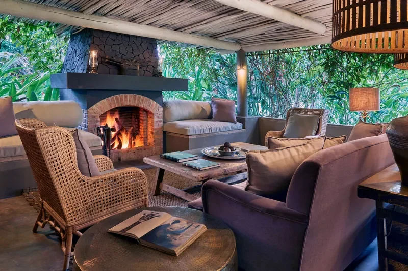 Covered outdoor lounge and fireplace at Legendary Lodge Arusha, relaxed social space in gardens