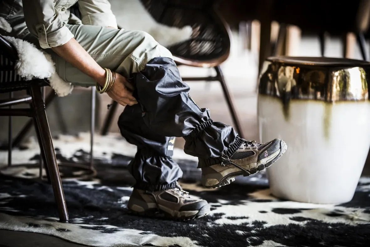 Lacing trekking gaiters at Bisate Lodge before gorilla hike Rwanda