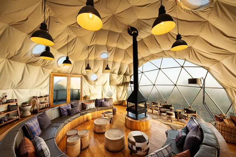 Main lounge inside The Highlands central dome with fireplace and crater facing seating, Ngorongoro