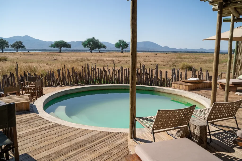Main circular pool and sun deck with Zambezi escarpment views, Nyamatusi Mahogany, Mana Pools, Zimbabwe