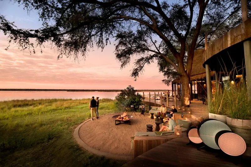 Sunken riverside firepit and lounge at Lolebezi Lodge at sunset, Zambezi River views in Lower Zambezi National Park, Zambia, Nomara