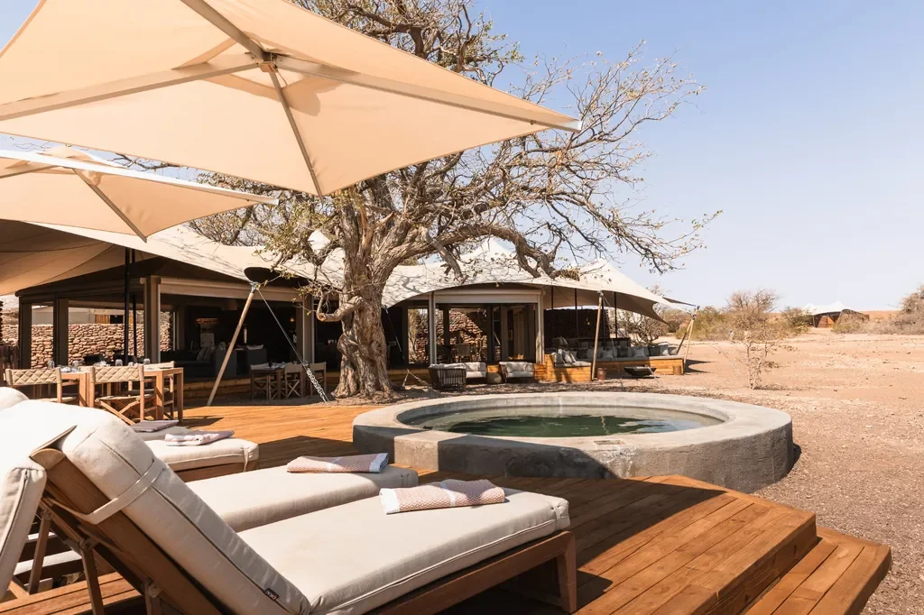 Circular plunge pool and sun deck with loungers at Desert Rhino Camp, Damaraland Namibia