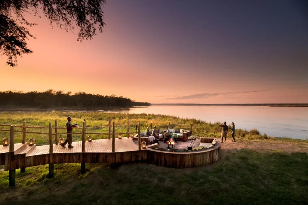 Sunset on Lolebezi riverside deck and sunken firepit on the Zambezi, Lower Zambezi National Park, Zambia