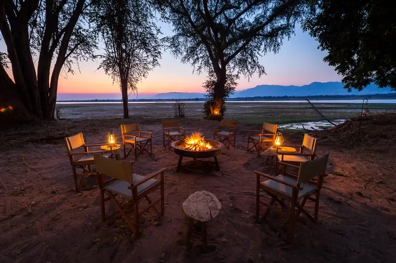 Campfire circle at sunset beside the Zambezi River at Little Ruckomechi, Mana Pools National Park, Zimbabwe