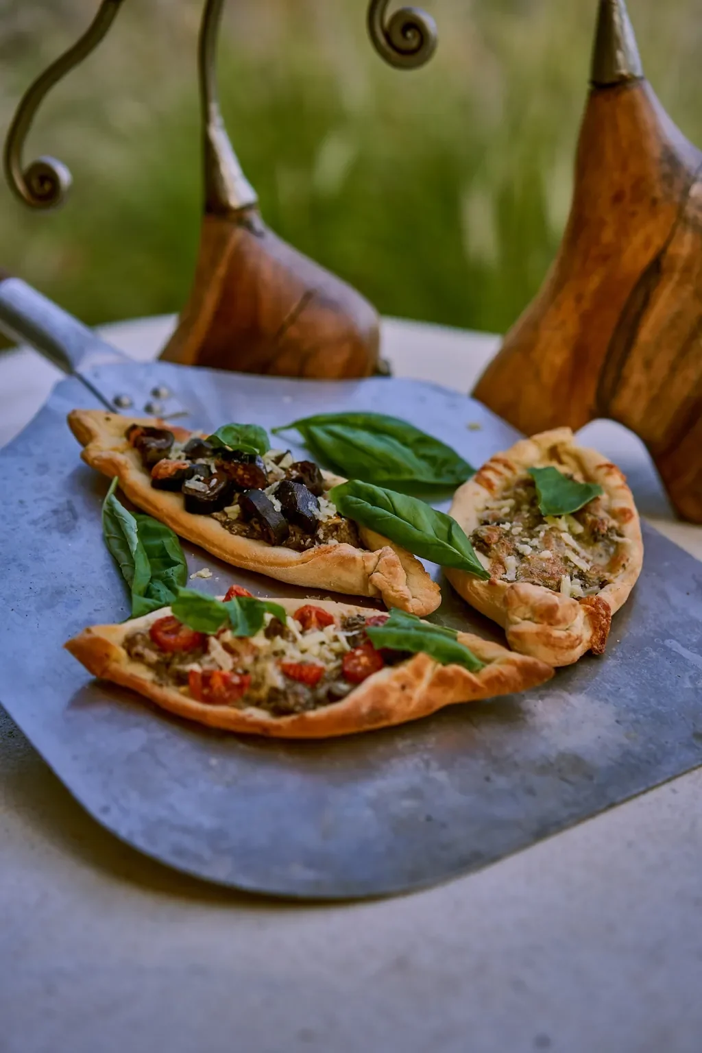 Freshly baked pide-style flatbreads from Sasaab’s outdoor pizza oven, topped with herbs and tomatoes, Samburu, Kenya
