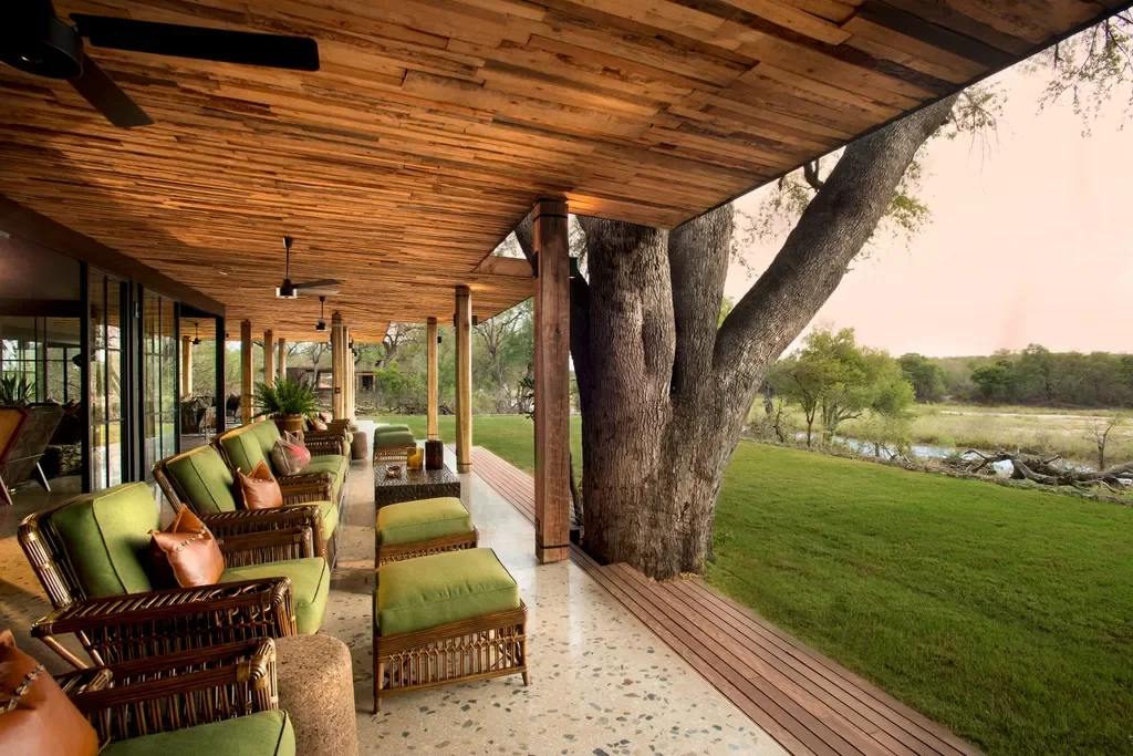 Open-air guest veranda with green lounge seating at Tengile River Lodge overlooking the river