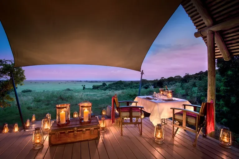 nomara-luxury-honeymoons-kenya-bateleur-camp-guest-delight-romantic-dining-at-sunset-with-lanterns-768w.webp