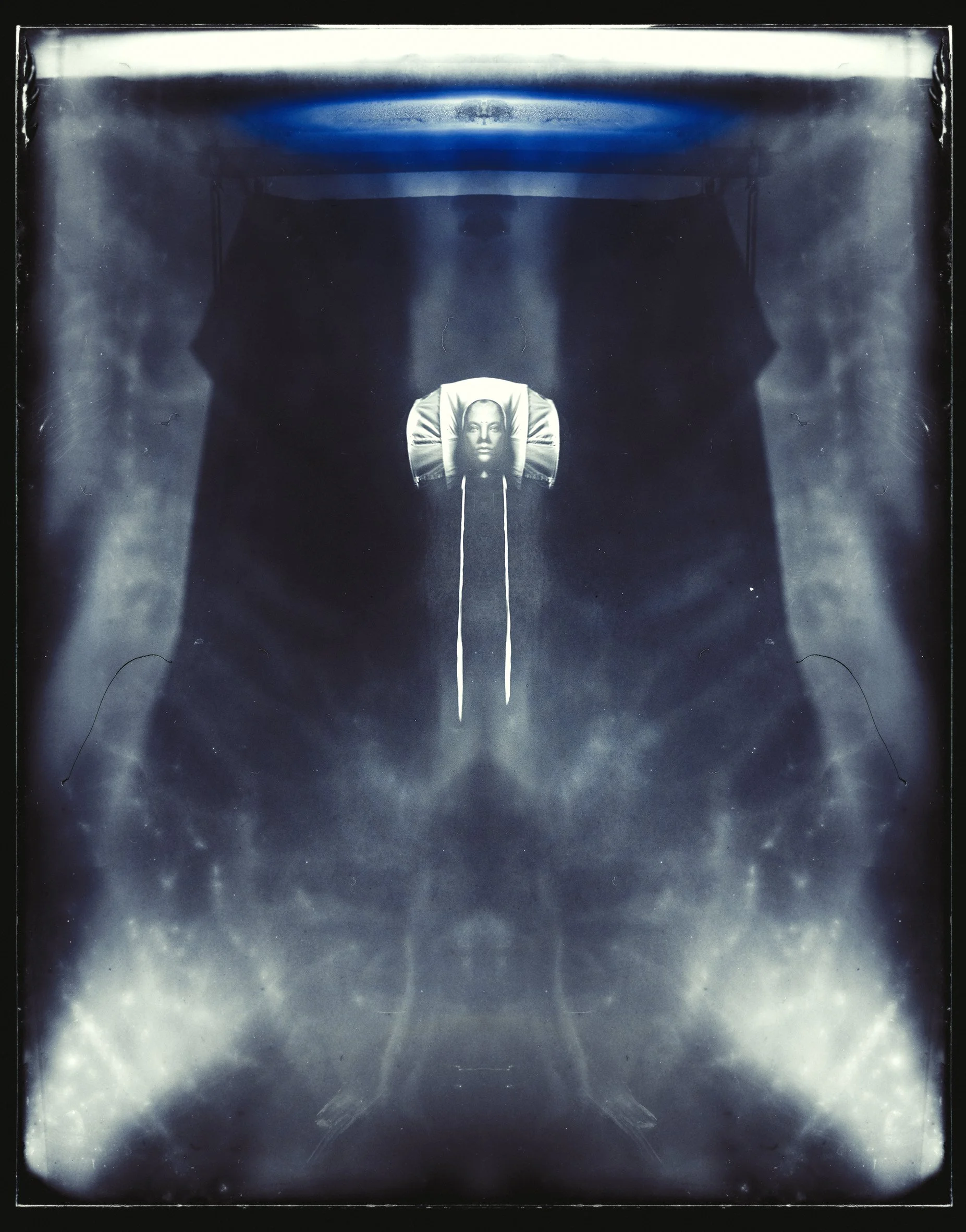 An abstract, symmetrical digital artwork featuring a central female face, surrounded by dark shapes and light accents, giving a surreal and cosmic impression.