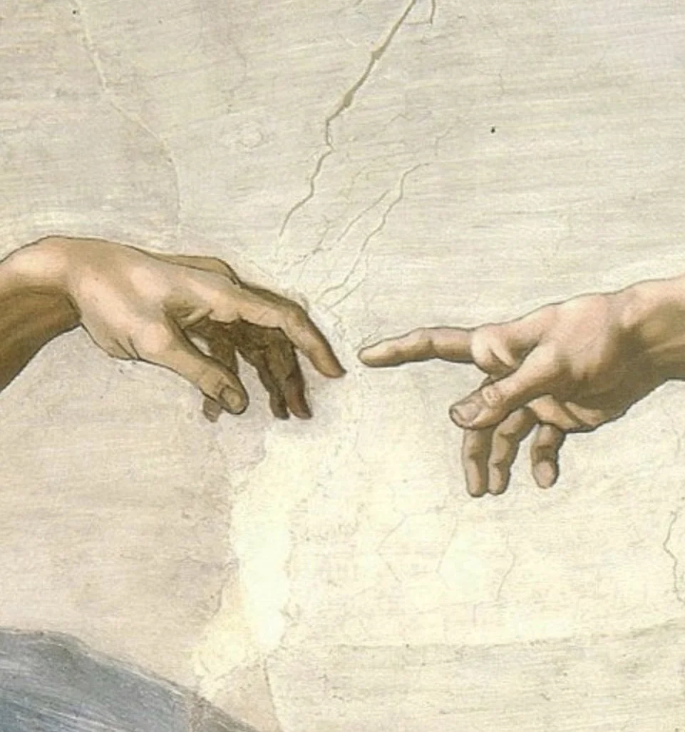 Close-up of a hand with rings resting on a draped white fabric, with a red coat and white shirt cuff.