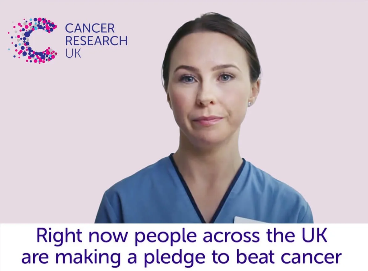 Une femme en uniforme médical avec le logo de Cancer Research UK, exprimant un message de soutien à la lutte contre le cancer au Royaume-Uni. Un texte en anglais en bas de l'image dit : "Right now people across the UK are making a pledge to beat cancer."