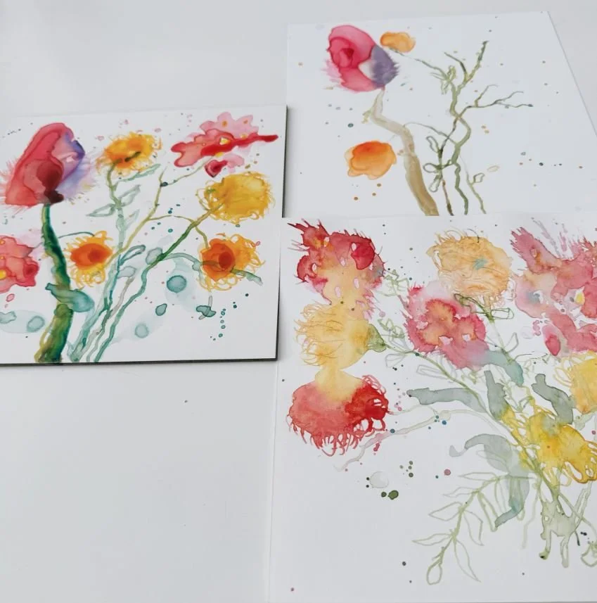 Three watercolour paintings of colorful abstract flowers on white paper.