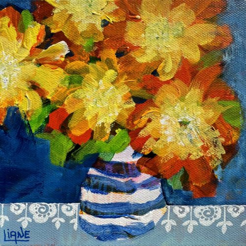 Bright yellow and orange flowers in a blue and white striped vase on a table with a patterned cloth, painted in an impressionistic style.