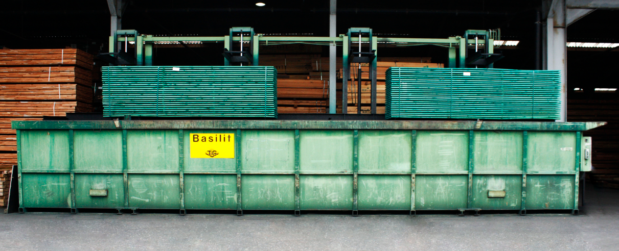Staalcontainer op een betonnen vloer in een magazijn of fabriekshal.