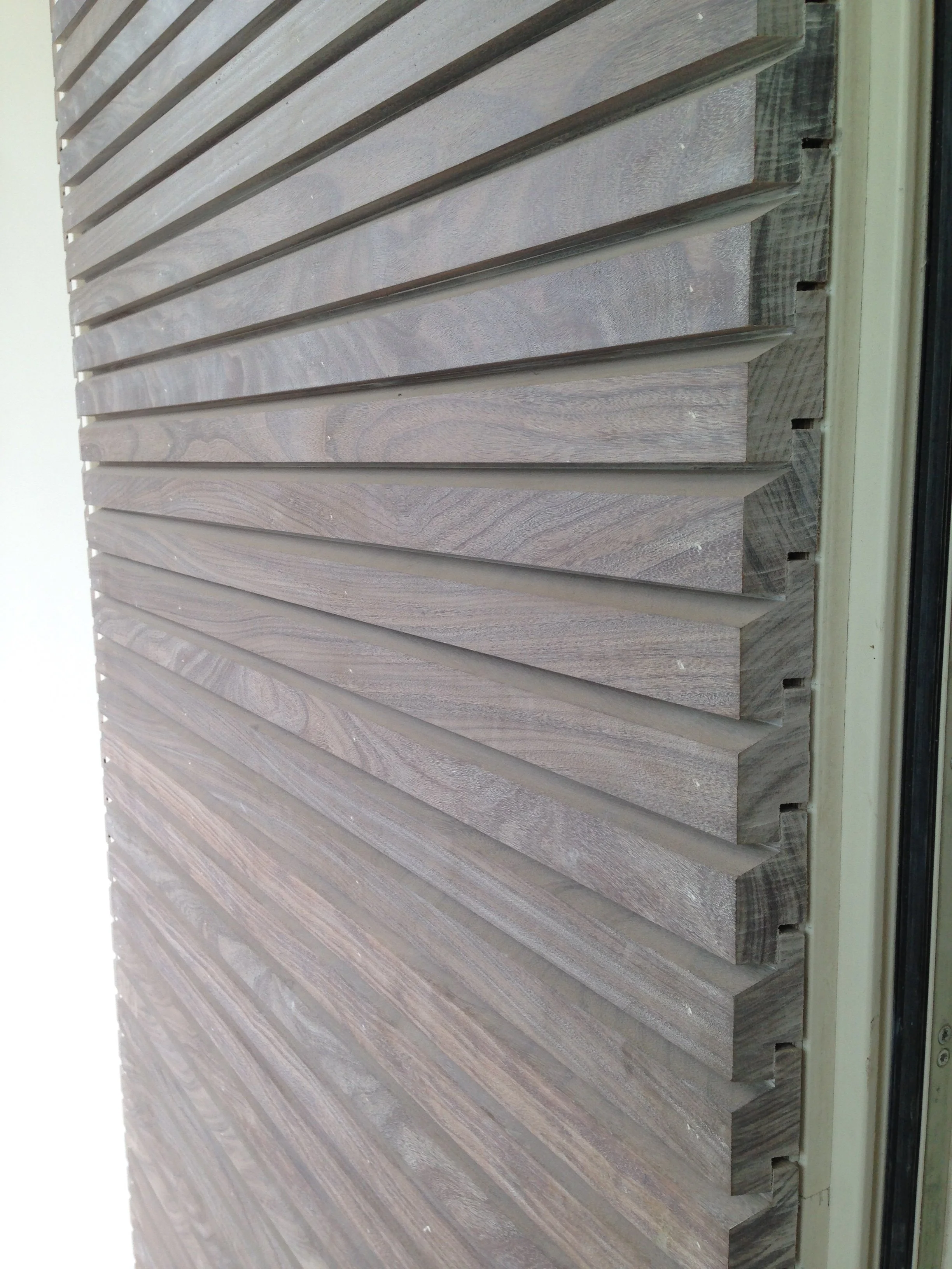 Close-up van houten gevelbekleding met horizontale panelen.
